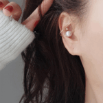 1對小巧精緻的銀色珍珠耳環，優雅簡約的設計，具有高貴感